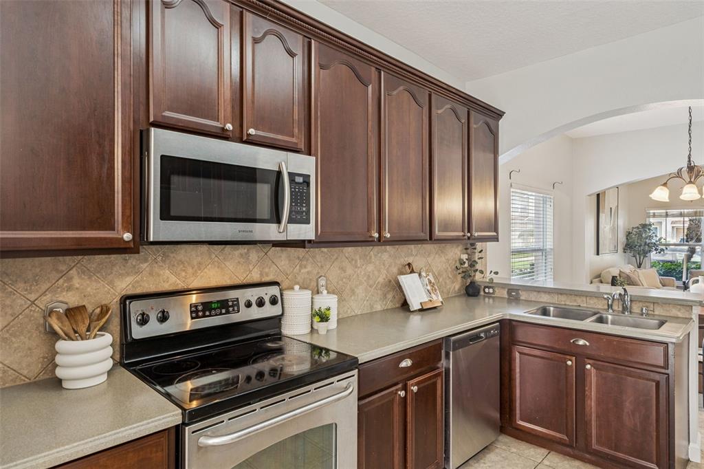 16178 Old Ash Loop Orlando, FL 32828 - Photo 7 of 24 a kitchen with wooden cabinets and a stove top oven