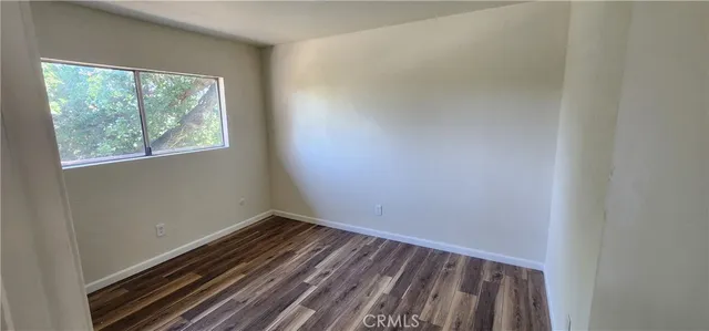 a view of a room with wooden floor and windows