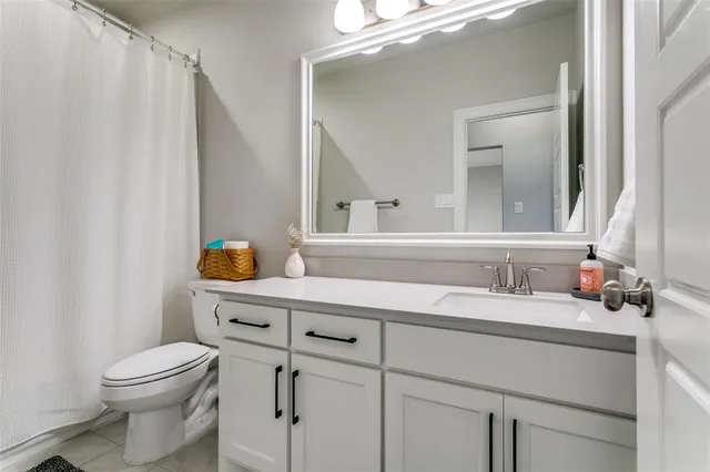 a bathroom with a sink a toilet and mirror