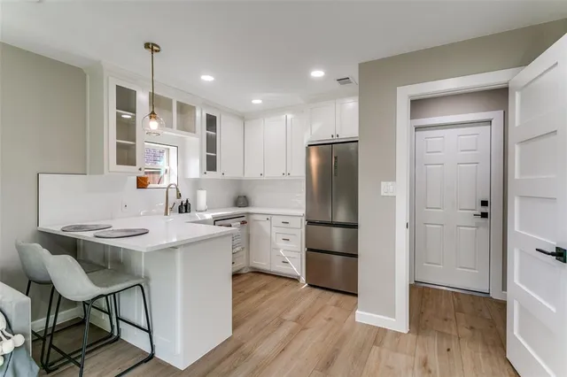 a kitchen with a refrigerator a sink dishwasher and a stove with wooden floor