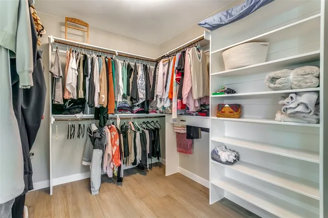 a view of walk in closet with clothes and shoes