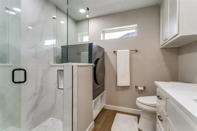 a bathroom with a granite countertop toilet sink and shower