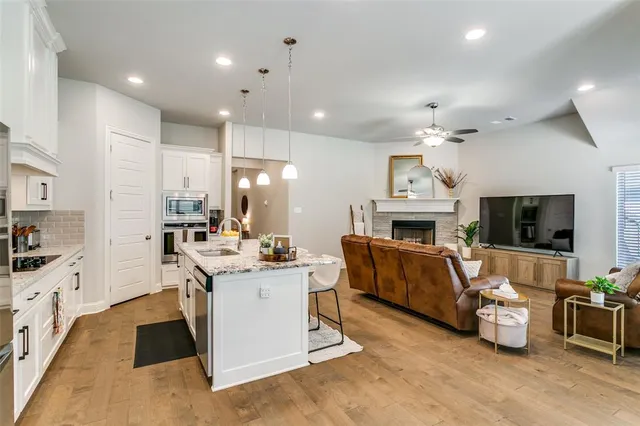 a living room with furniture a flat screen tv and kitchen view