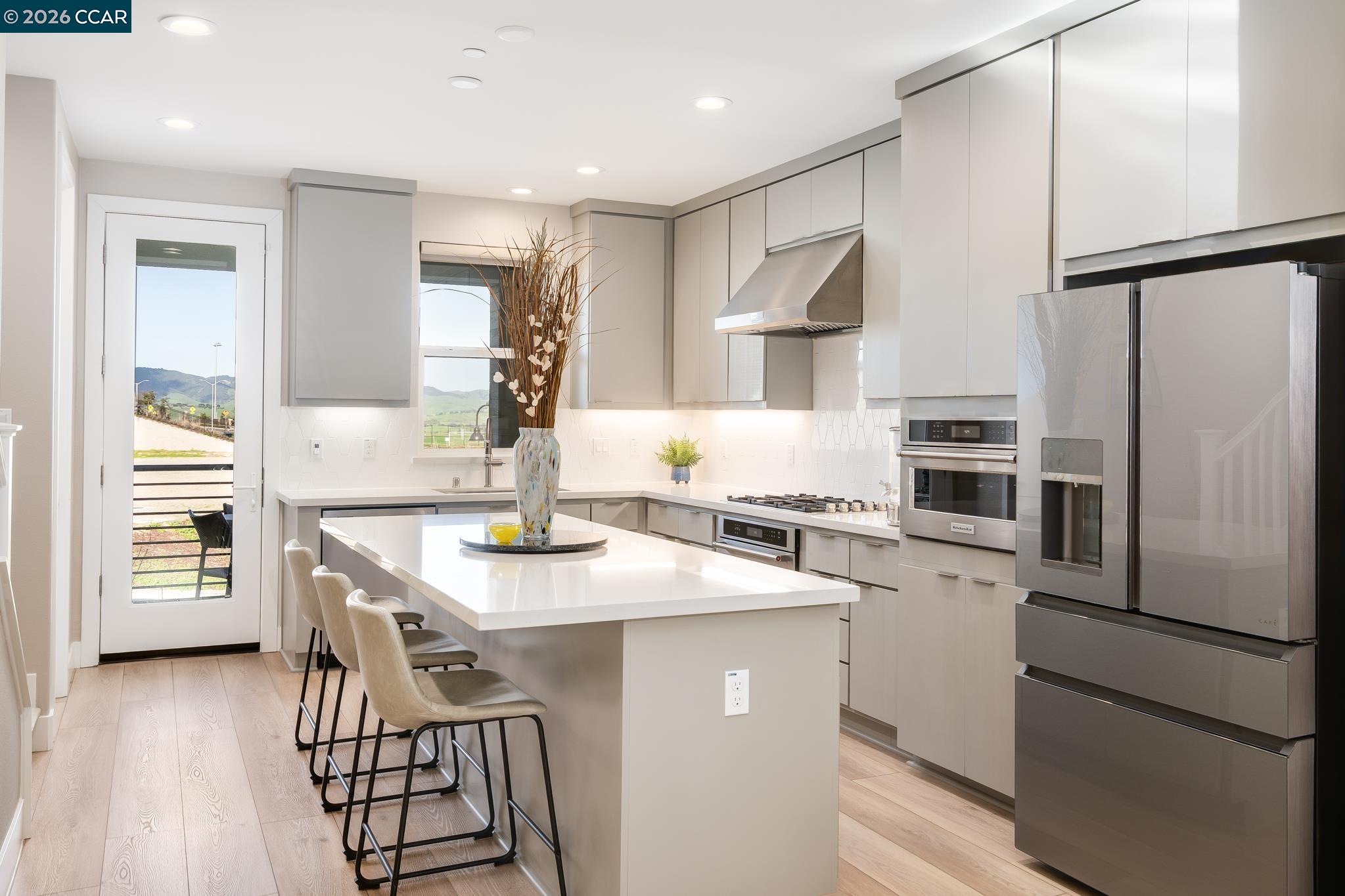 1200 Lorenzini Loop San Ramon, CA 94583 - Photo 4 of 35 a kitchen with stainless steel appliances kitchen island a refrigerator and a stove top oven