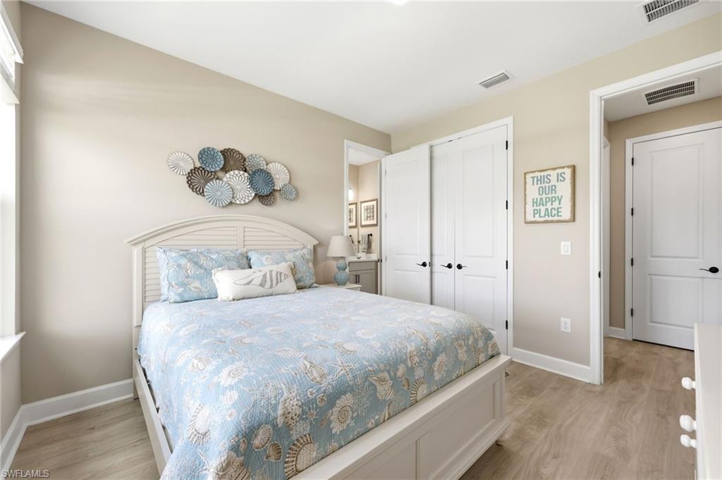 2094 Grove Drive Naples, FL 34120 - Photo 16 of 40 a bedroom with a bed and wooden floor