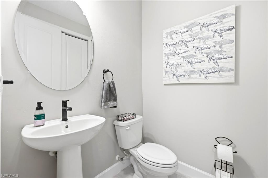 2094 Grove Drive Naples, FL 34120 - Photo 20 of 40 a bathroom with a toilet sink and mirror