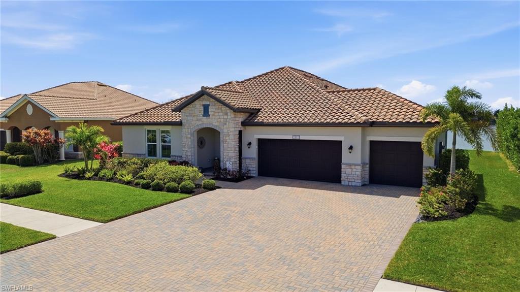 2094 Grove Drive Naples, FL 34120 - Photo 2 of 40 a front view of a house with a garden and plants