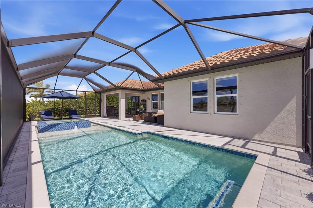 2094 Grove Drive Naples, FL 34120 - Photo 28 of 40 a view of a backyard with table and chairs under an umbrella