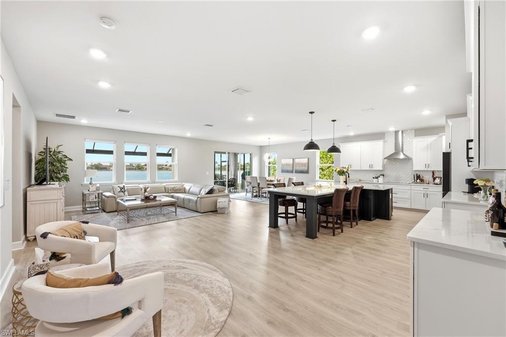 2094 Grove Drive Naples, FL 34120 - Photo 3 of 40 a living room with furniture and a dining table with kitchen view