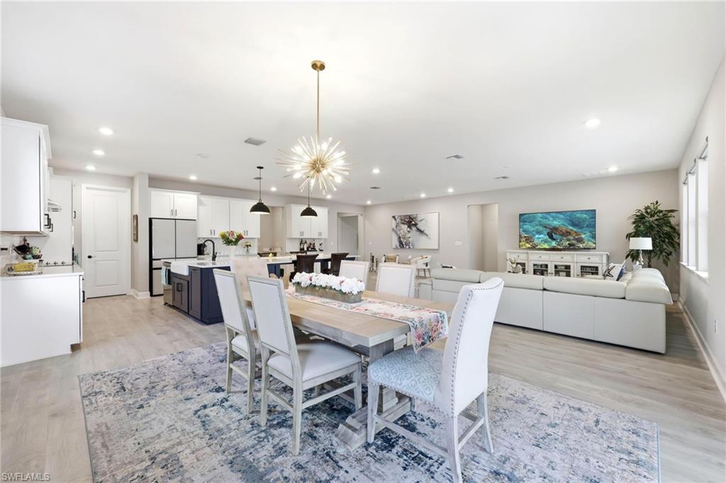 2094 Grove Drive Naples, FL 34120 - Photo 9 of 40 a view of a dining room and livingroom with furniture wooden floor a chandelier