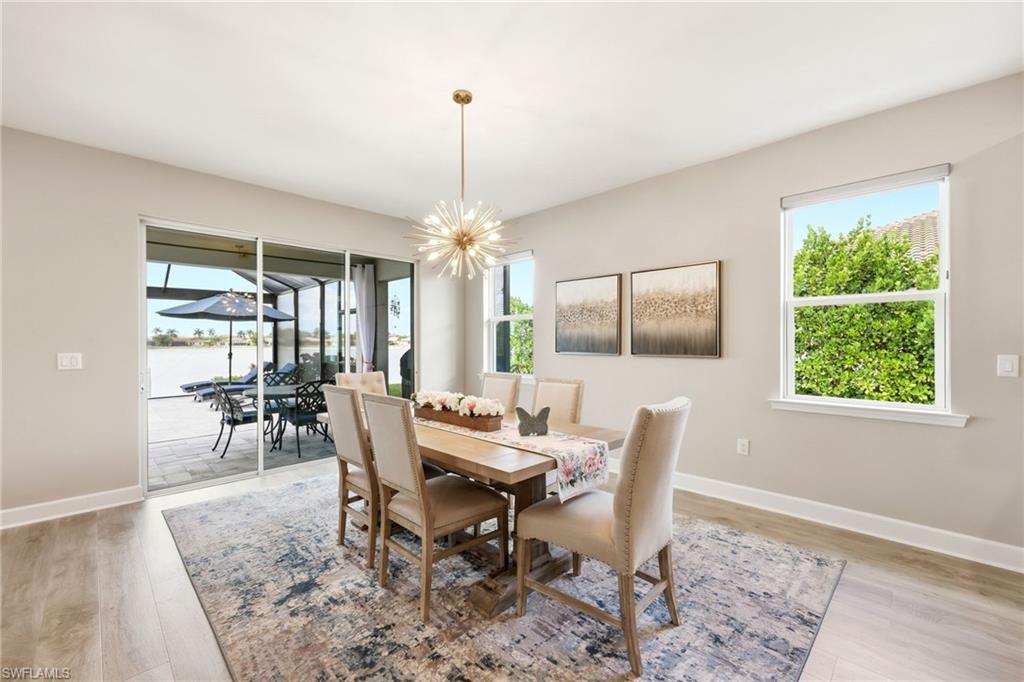 2094 Grove Drive Naples, FL 34120 - Photo 10 of 40 a dining room with furniture a chandelier and wooden floor