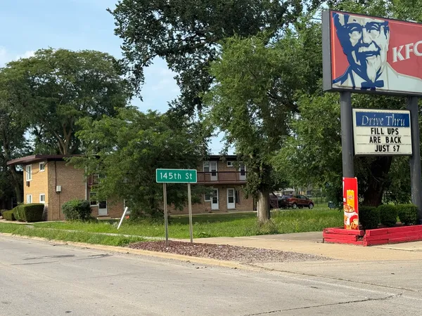 a green field with trees in the background