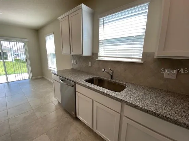 a kitchen with granite countertop a sink and a window