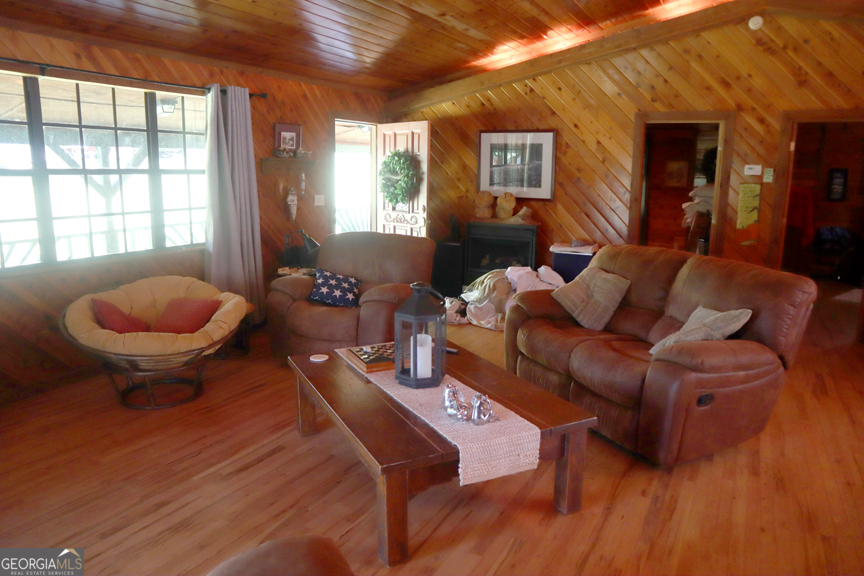 671 Pine Lake Sparta, GA 31087 - Photo 20 of 31 a living room with furniture a rug and a large window