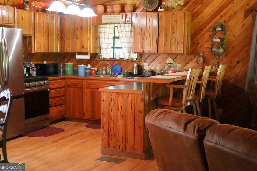671 Pine Lake Sparta, GA 31087 - Photo 22 of 31 a kitchen with stainless steel appliances wooden floor and a refrigerator