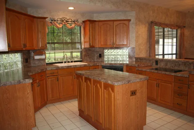 a kitchen with stainless steel appliances granite countertop wooden cabinets a sink and a window