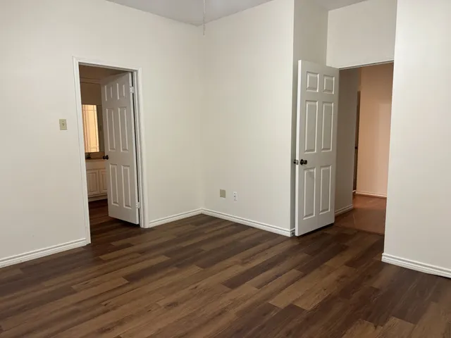 an empty room with wooden floor and closet