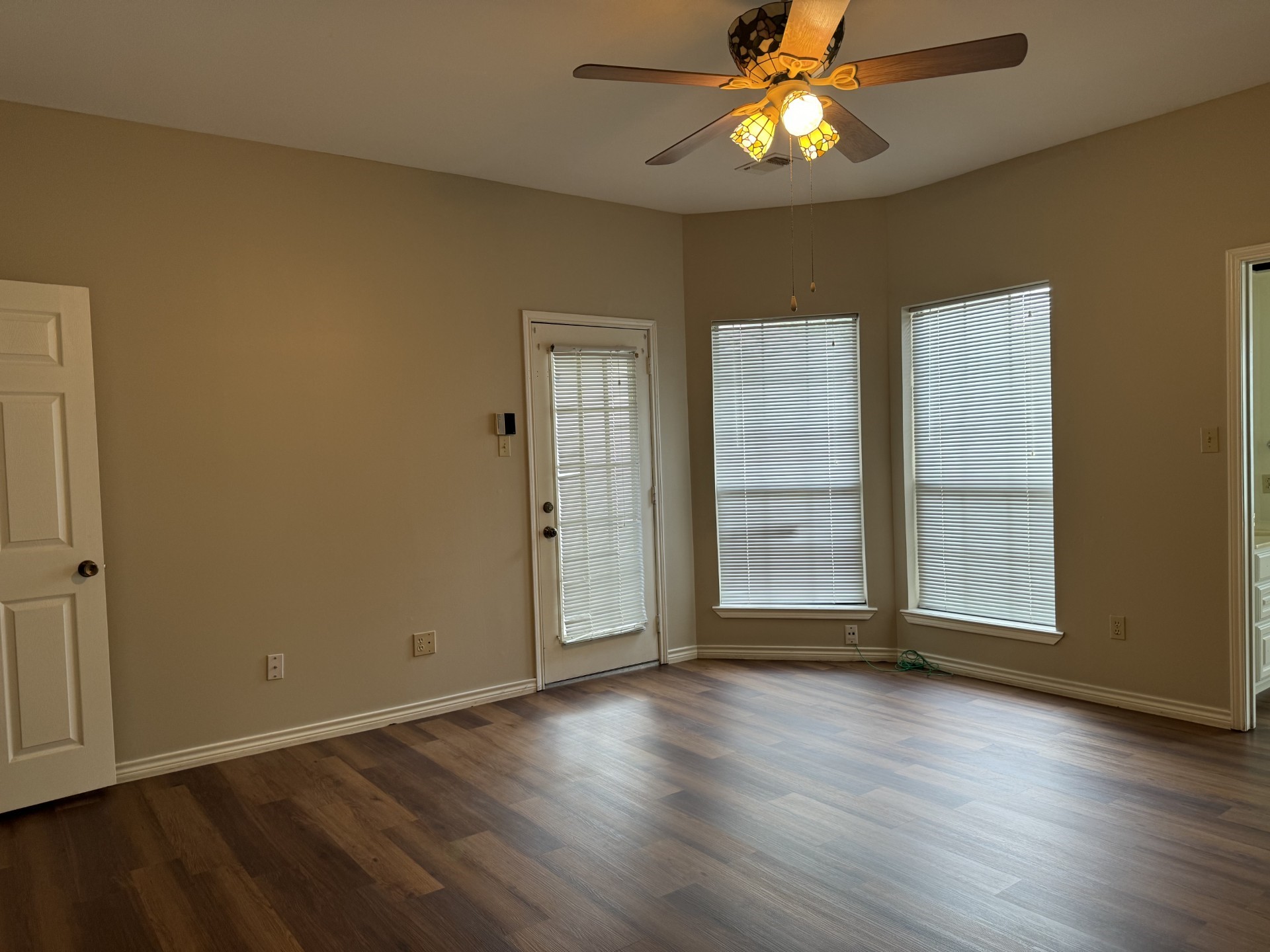 12223 A Old Huffmeister Road Cypress, TX 77429 - Photo 21 of 31 an empty room with wooden floor chandelier fan and windows