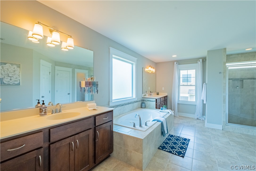4935 Turner Ridge Court Glen Allen, VA 23059 - Photo 31 of 50 a spacious bathroom with a sink a mirror a bathtub and next to a window