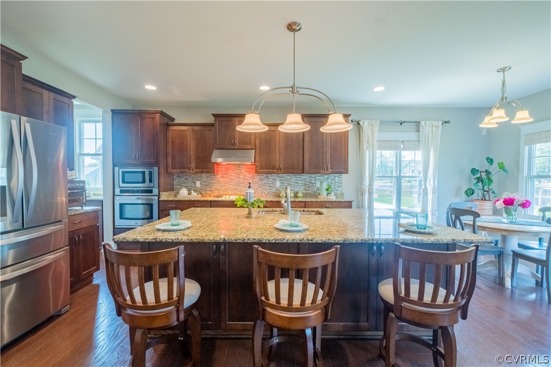 4935 Turner Ridge Court Glen Allen, VA 23059 - Photo 9 of 50 a kitchen with stainless steel appliances granite countertop a stove a refrigerator a kitchen island a dining table and chairs with wooden floor