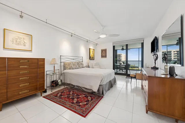 a spacious bedroom with a bed a dresser and next to a window