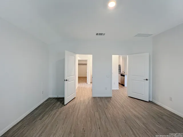 a view of an empty room with wooden floor