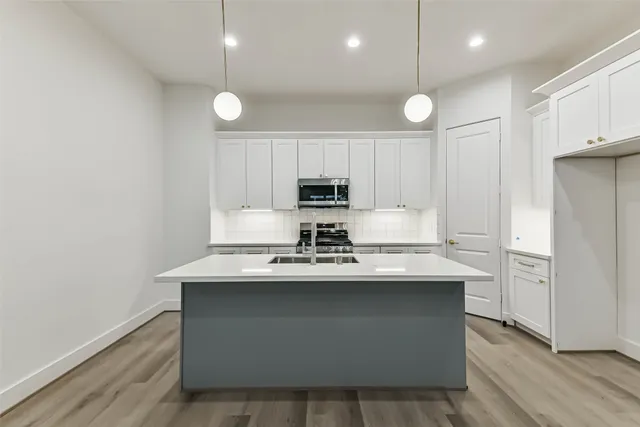 a kitchen with stainless steel appliances granite countertop a sink a stove and a refrigerator