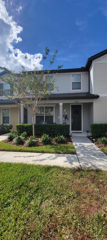 a view of a house with a yard and potted plants