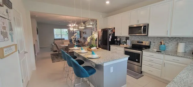 a kitchen with a sink a stove and chairs