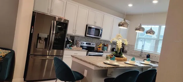 a kitchen with stainless steel appliances a refrigerator sink stove microwave and cabinets