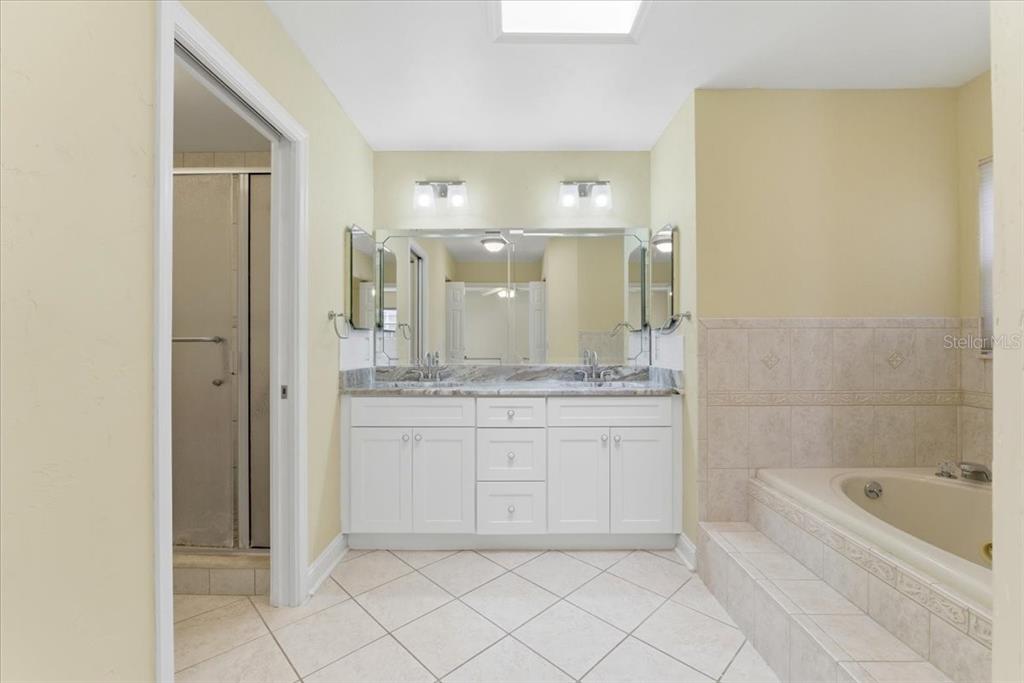 3650 Wildcat Run Lakeland, FL 33810 - Photo 22 of 59 a bathroom with a granite countertop sink a mirror and a bathtub