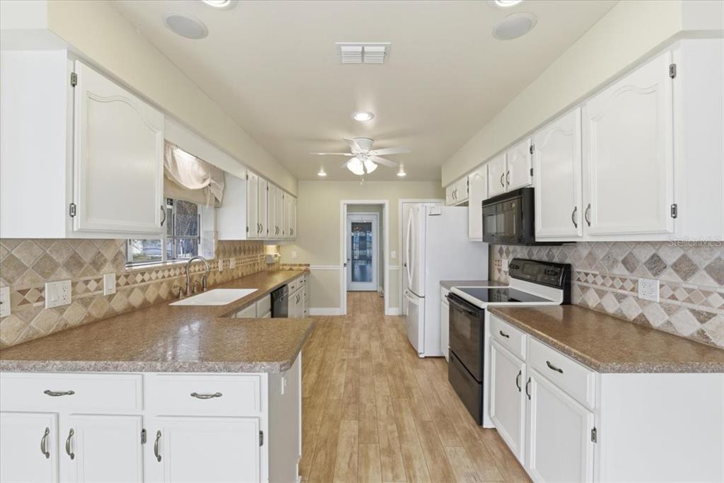 3650 Wildcat Run Lakeland, FL 33810 - Photo 5 of 59 a kitchen with granite countertop a sink a counter top space stainless steel appliances and cabinets