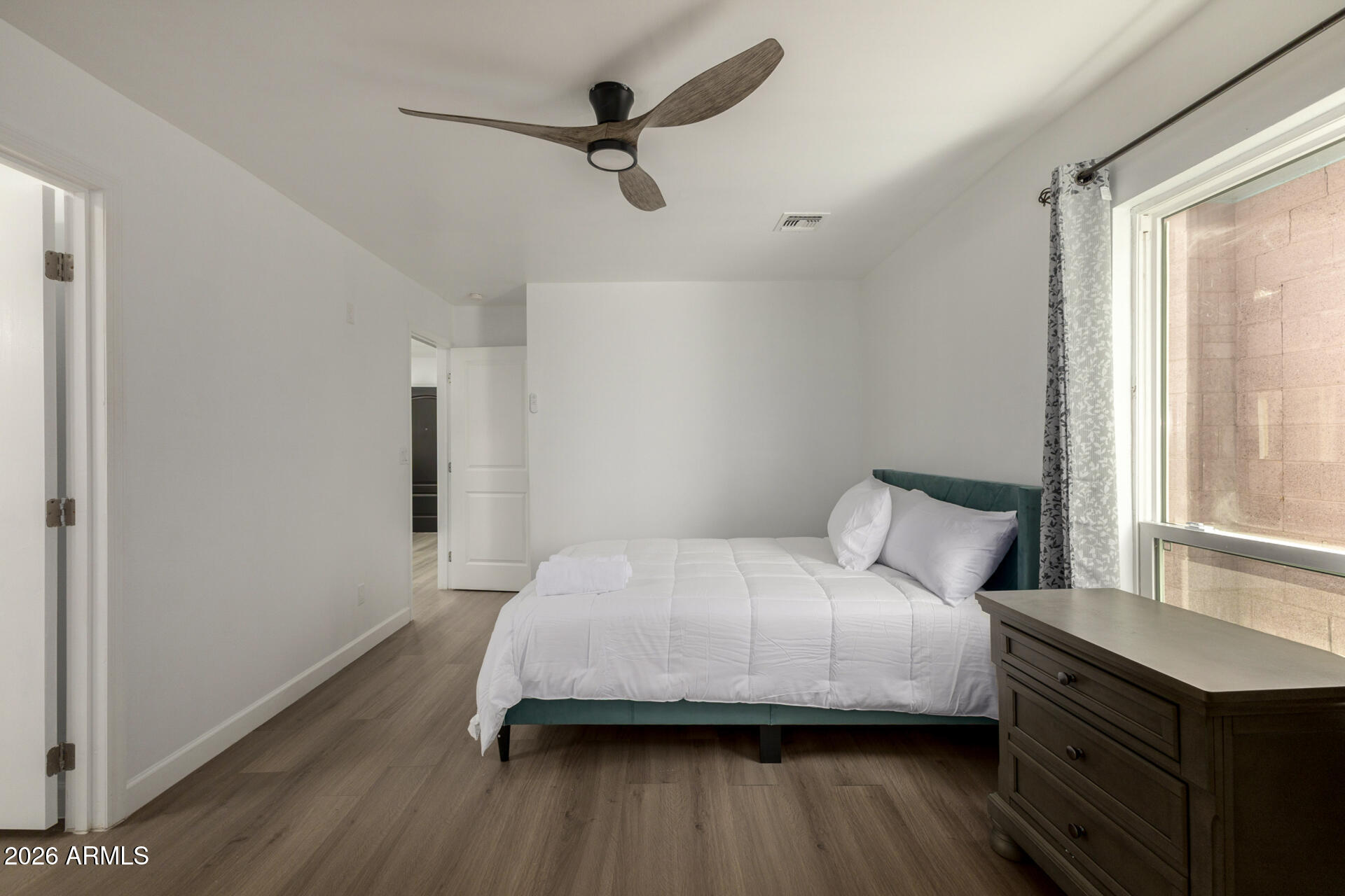 2142 West Coolidge Street Phoenix, AZ 85015 - Photo 14 of 28 a bedroom with a bed a dresser and a window