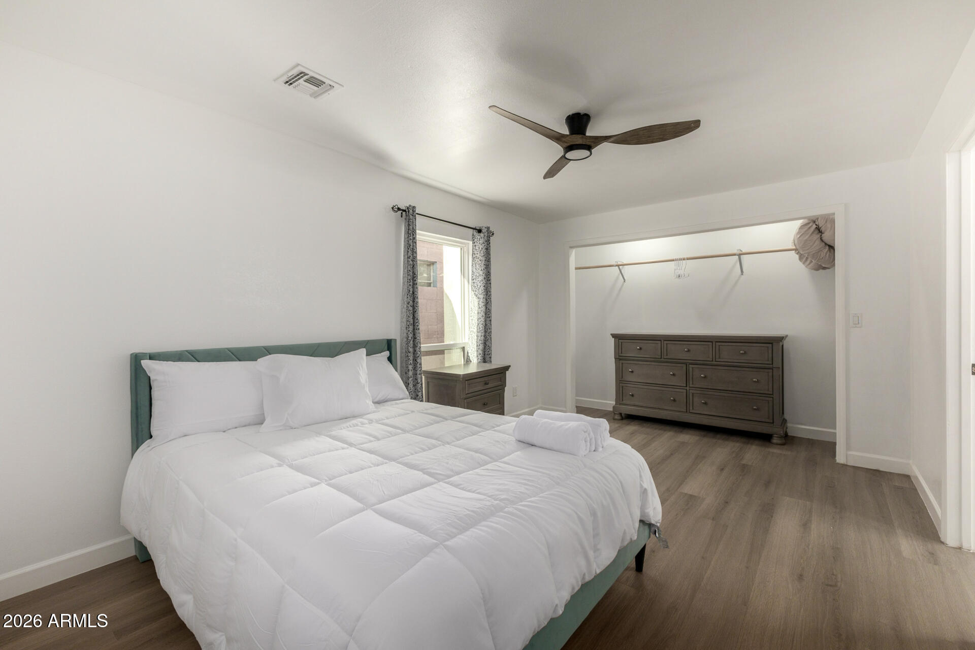 2142 West Coolidge Street Phoenix, AZ 85015 - Photo 16 of 28 a bedroom with a bed a mirror and a hardwood