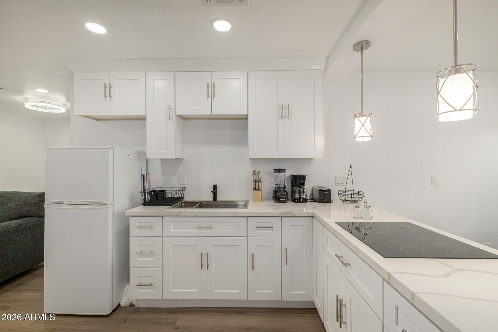 2142 West Coolidge Street Phoenix, AZ 85015 - Photo 20 of 28 a kitchen with a sink dishwasher and white cabinets with wooden floor