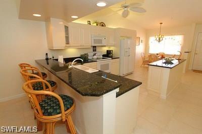 6650 Beach Resort Drive, Unit 908 Naples, FL 34114 - Photo 6 of 15 a kitchen with a table and chairs