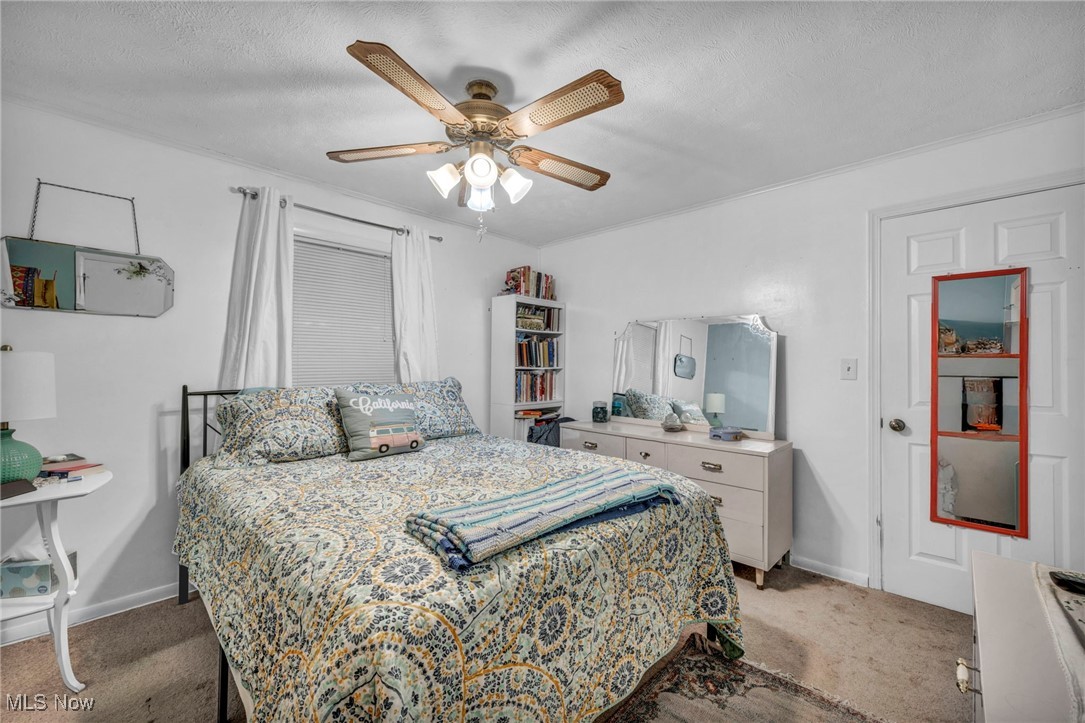 3285 Stoney Ridge Road Avon, OH 44011 - Photo 22 of 43 Carpeted bedroom featuring ceiling fan, a textured ceiling, and ornamental molding