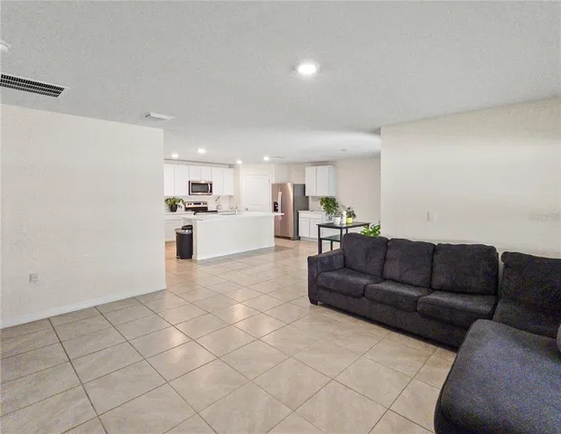 a living room with furniture and kitchen view