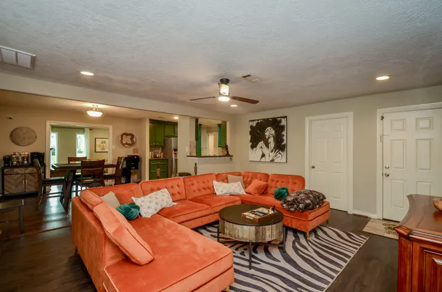 a living room with furniture a ceiling fan and a rug