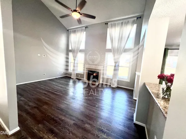 a view of a livingroom with wooden floor and a fireplace