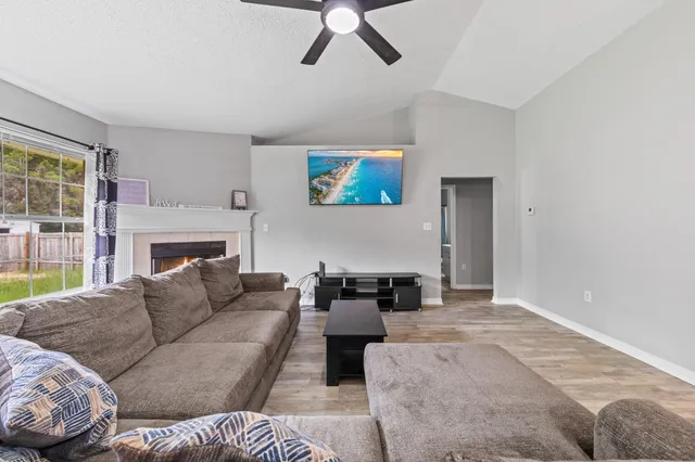 a living room with furniture a fireplace and a large window