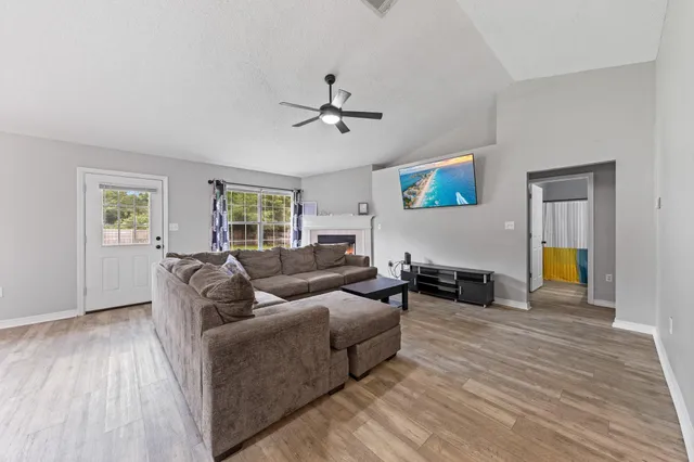 a living room with furniture and a wooden floor