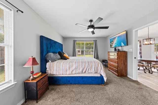 a spacious bedroom with a bed and a chandelier