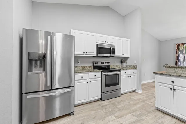 a kitchen with stainless steel appliances a refrigerator stove and microwave