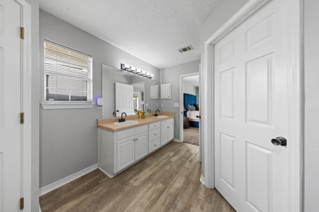 a large white room with kitchen island wooden floor