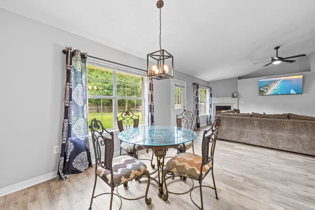 a dining room with furniture a chandelier and wooden floor