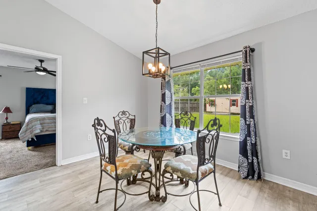 a dining room with furniture a chandelier and wooden floor