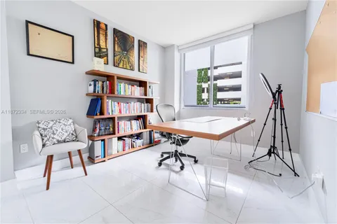 a view of a workspace with furniture and a book shelf