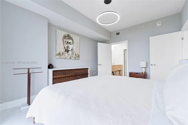 a bedroom with a bed and a large mirror