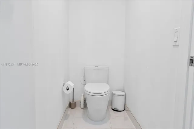 a white toilet sitting next to a white cabinet